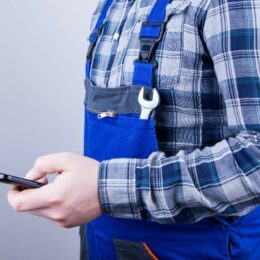 Ein Handwerker hält sein Handy in der Hand