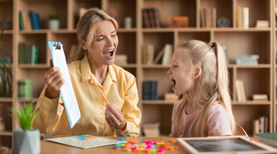 Eine Frau und ein Mädchen üben Buchstaben lesen