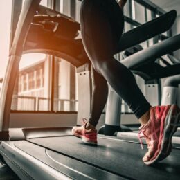 Eine junge Frau die auf einem Laufband joggt