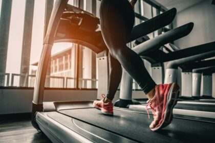 Eine junge Frau die auf einem Laufband joggt