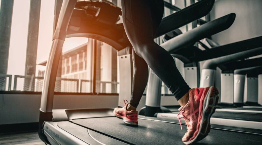 Eine junge Frau die auf einem Laufband joggt