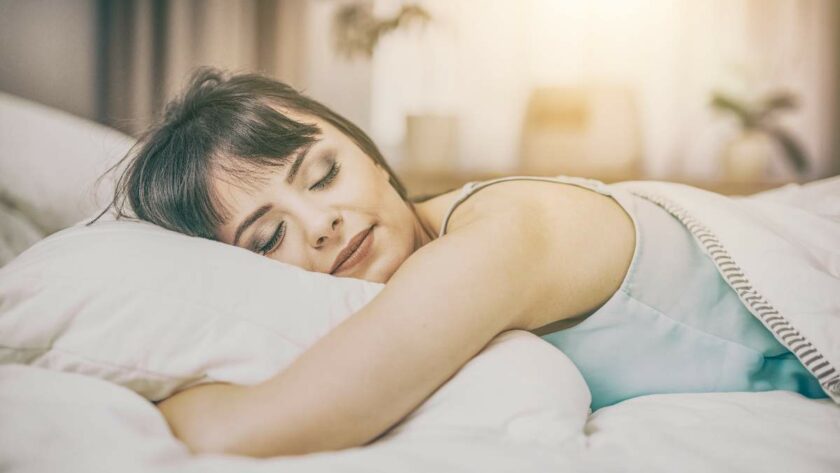 Eine junge Frau liegt schlafend im Bett