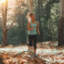 Eine junge Frau die im Wald joggt
