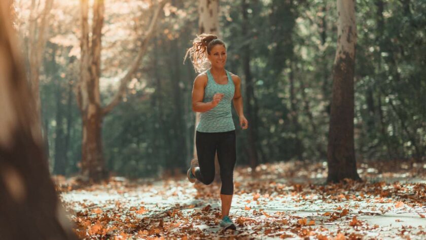 Eine junge Frau die im Wald joggt