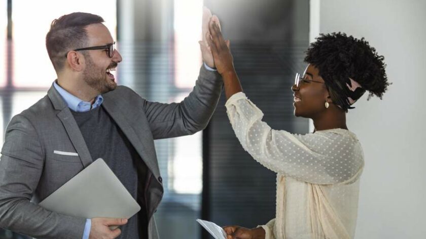 Geschäftsmann und Geschäftsfrau geben sich ein Highfive