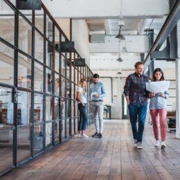 Junge Mitarbeitende in einem Unternehmen in einem großzügigen modernen Büroraum