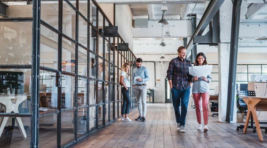 Junge Mitarbeitende in einem Unternehmen in einem großzügigen modernen Büroraum