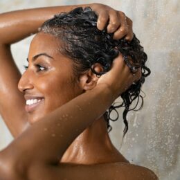 Frau wäscht sich unter der Dusche die Haare