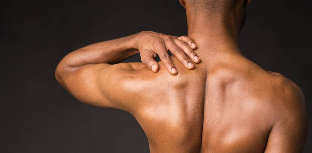 Mann massiert sich den Nacken Rückenansicht nackter Rücken