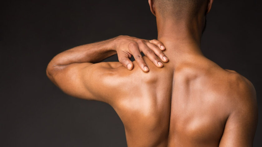 Mann massiert sich den Nacken Rückenansicht nackter Rücken