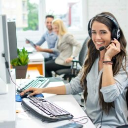 Freundliche Call-Center-Mitarbeiterin erledigt Telefonservice für virtuelles Buero