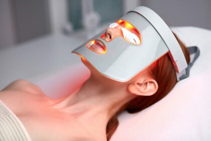 Frau mit LED-Maske liegt bei der Lichttherapie