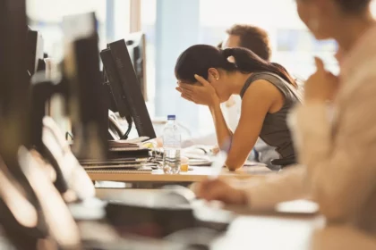 Gestresste Frau im Büro muss mit Stress umgehen lernen