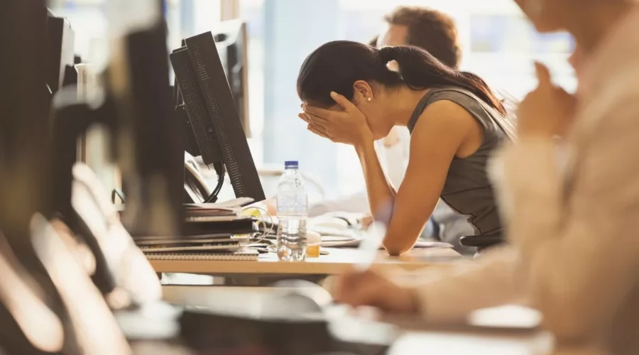 Gestresste Frau im Büro muss mit Stress umgehen lernen